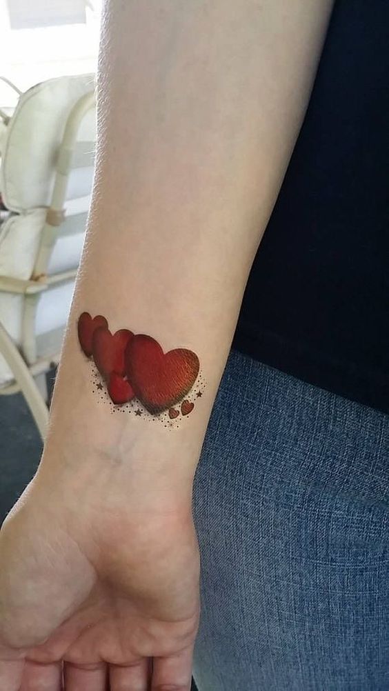 Tatouage Coeurs Rouges Et étoiles Sur L'avant Bras