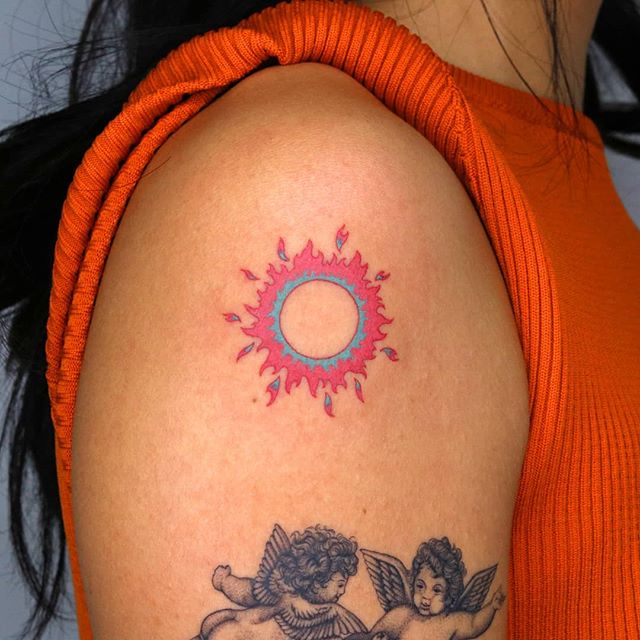 Tatouage Soleil Bleu Et Rouge Vif Sur Le Bras