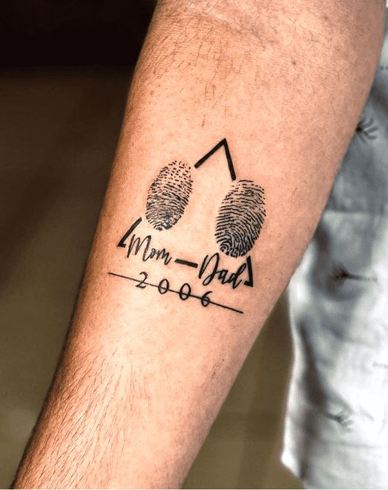 Tatouage Année D'anniversaire Avec Empreintes Et Mots Sur L'avant Bras