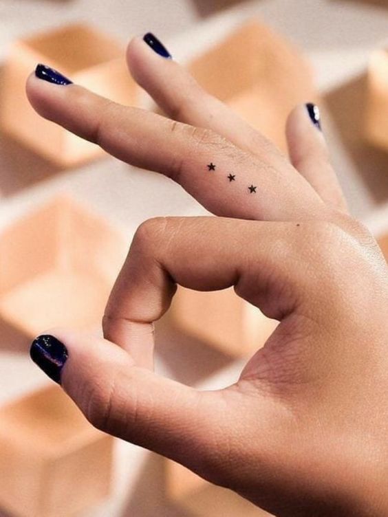 Tatouage Trois étoiles Noires Discrètes Sur Le Doigt