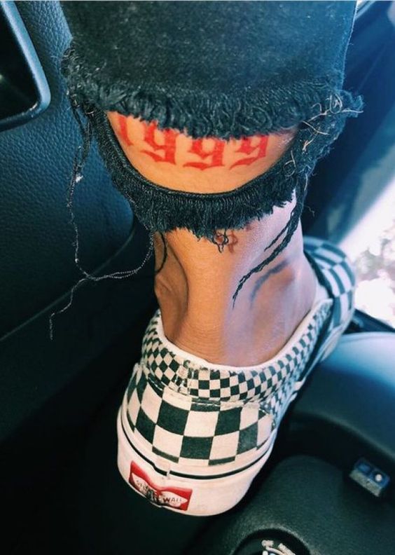 Tatouage Année De Naissance à L'encre Rouge Sur La Jambe