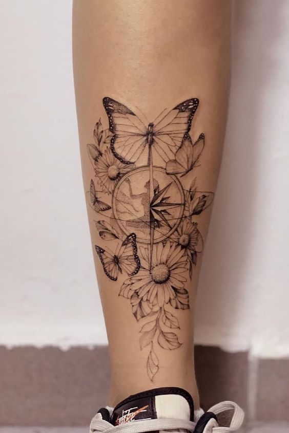Tatouage Papillons, Fleurs Et Boussole Sur Le Mollet