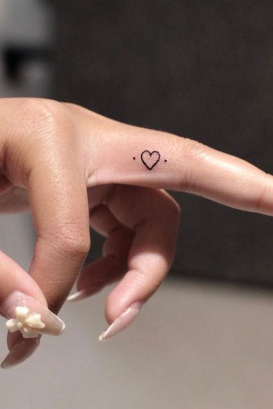 Tatouage Coeur Et Deux Points Noirs Sur Le Doigt