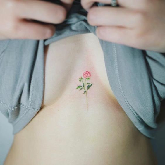 Tatouage Fleur Rouge Et Feuilles Vertes Sur Le Sternum