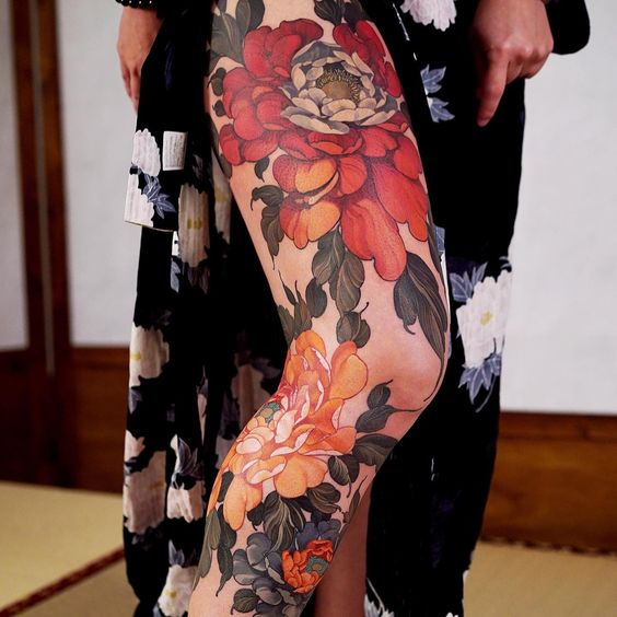 Tatouage Pivoines Rouge Et Orange Sur La Cuisse