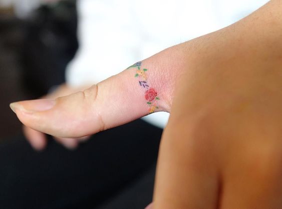 Tatouage Fleurs Multicolores Sur Le Doigt