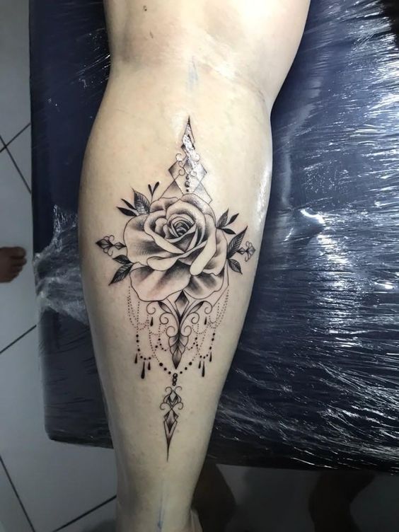 Tatouage Rose Et Bijoux En Noir Et Gris Sur Le Mollet