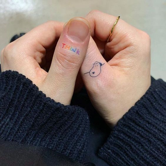 Tatouage Mot Think Et Chien Minimaliste Sur Le Doigt