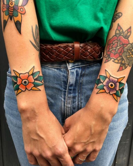 Tatouage Fleurs Orange Et Violette Sur Le Poignet