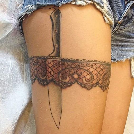 Tatouage Dentelle Rouge Avec Couteau De Cuisine Sur La Cuisse