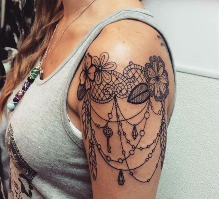 Tatouage Dentelle Avec Fleurs Et Pendentifs Sur Le Bras