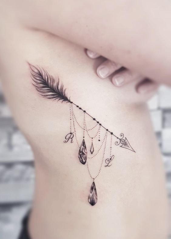 Tatouage Flèche Avec Bijoux Sur Les Côtes