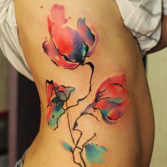 Tatouage Fleurs Rouges Et Bleues Sur Les Côtes