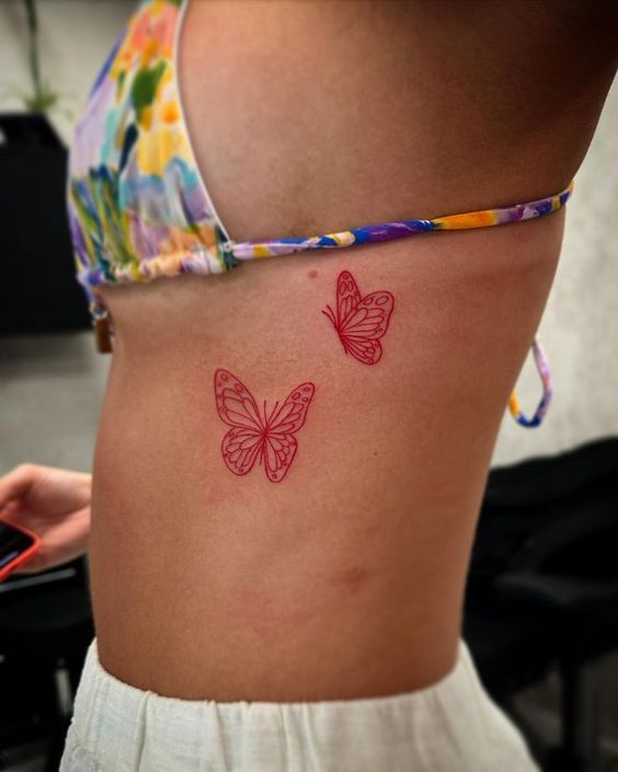 Tatouage Papillons à L'encre Rouge Sur Les Côtes