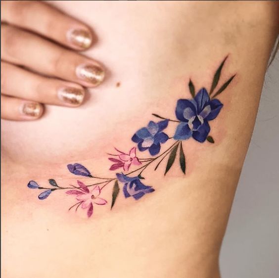 Tatouage Fleurs Bleues Et Roses Sur Les Côtes