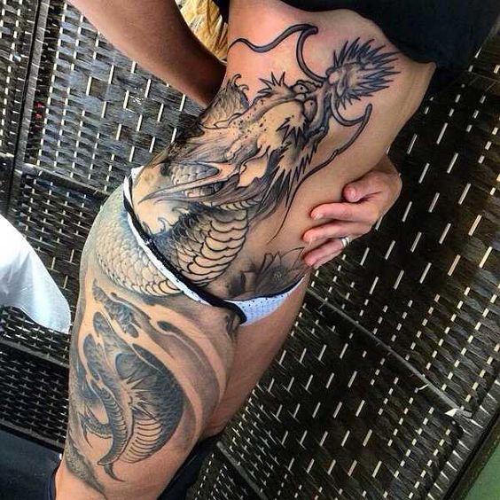 Tatouage Tête De Dragon En Noir Et Gris Sur Les Côtes