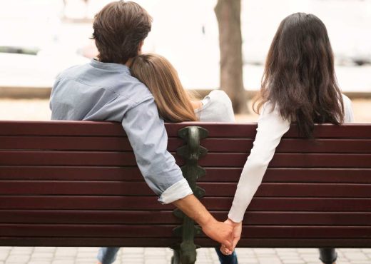 un homme et deux femmes de dos sur un banc, concept d'infidélité