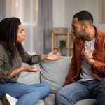 jeune couple en plein conflit sur le canapé