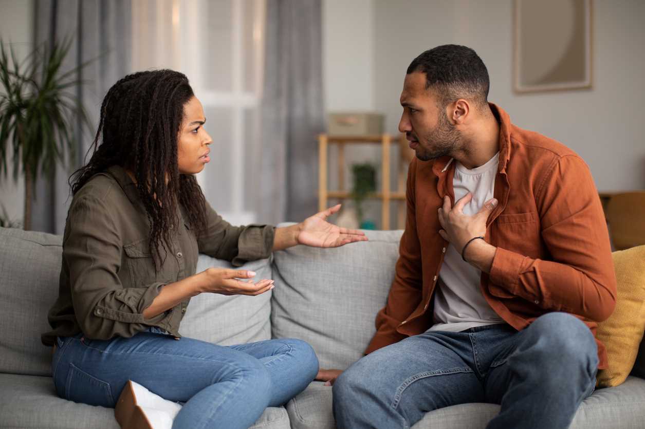 jeune couple en plein conflit sur le canapé