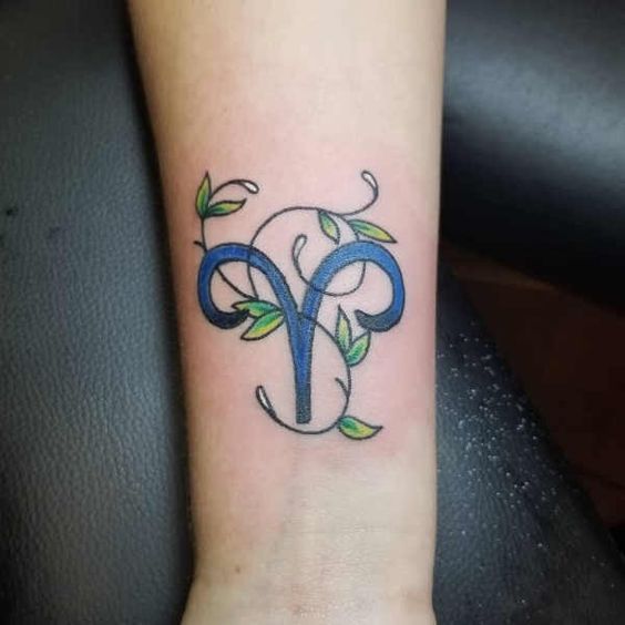 Tatouage Signe Bélier Avec Feuilles Vertes Sur L'avant Bras