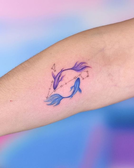 Tatouage Poissons Colorés Avec Constellation Sur L'avant Bras