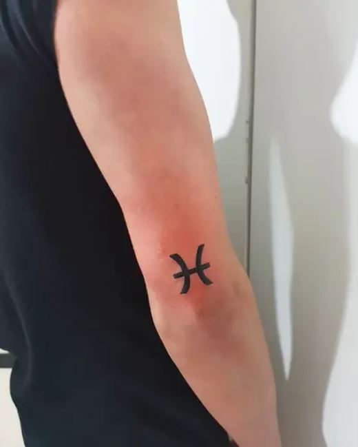 Tatouage Signe Poissons à L'encre Noire Sur Le Coude