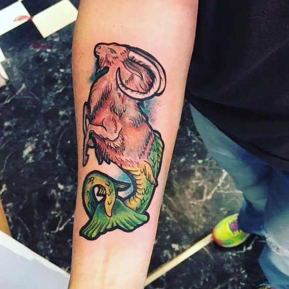 Tatouage Poisson Chèvre Vert Et Rouge Sur L'avant Bras