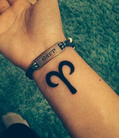 Tatouage Signe Bélier à L'encre Noire Sur Le Poignet