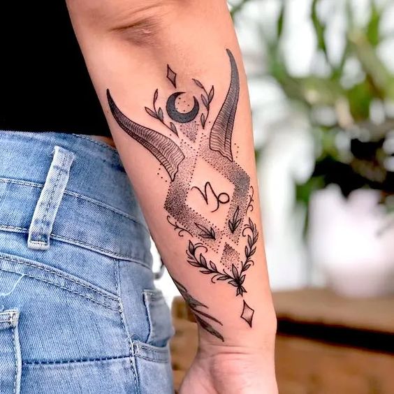 Tatouage Signe Capricorne Avec Lune, Cornes Et Feuilles Sur L'avant Bras