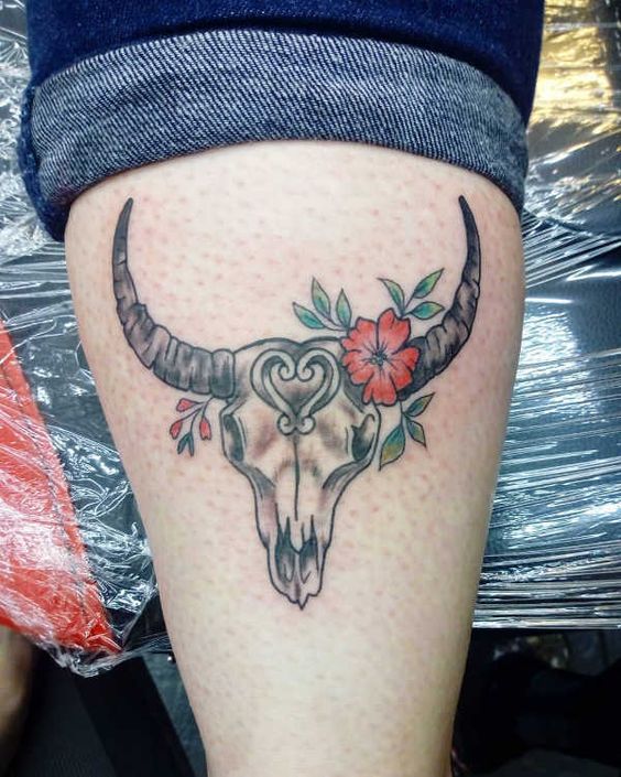 Tatouage Crâne De Taureau Et Fleurs Rouges Sur La Jambe