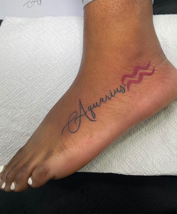 Tatouage Signe Verseau Et Mot Aquarus Sur La Cheville