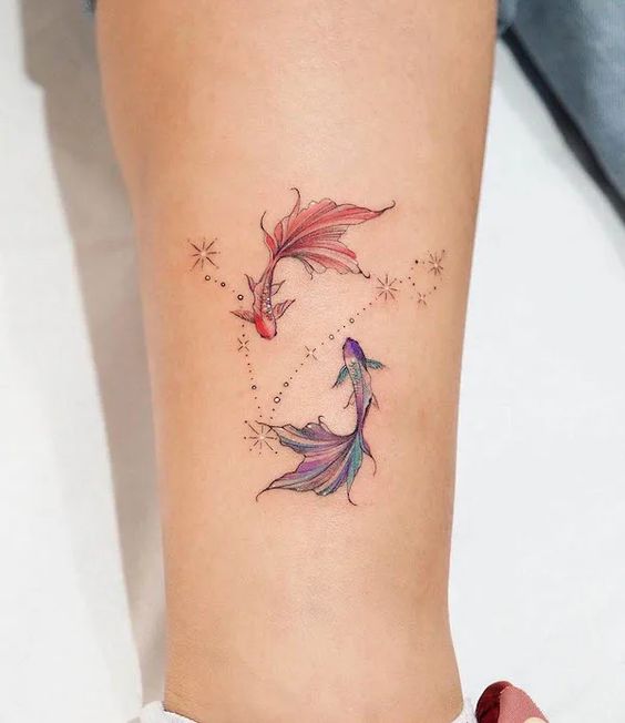 Tatouage Poissons Colorés Et Constellation Sur La Jambe