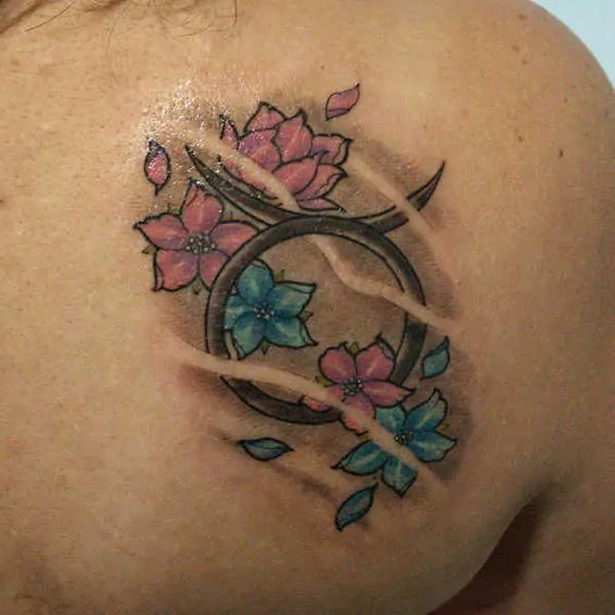 Tatouage Signe Taureau Avec Fleurs Roses Et Bleues Sur L'omoplate