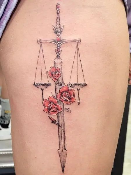 Tatouage Balance Avec épée Et Fleurs Rouges Sur La Cuisse