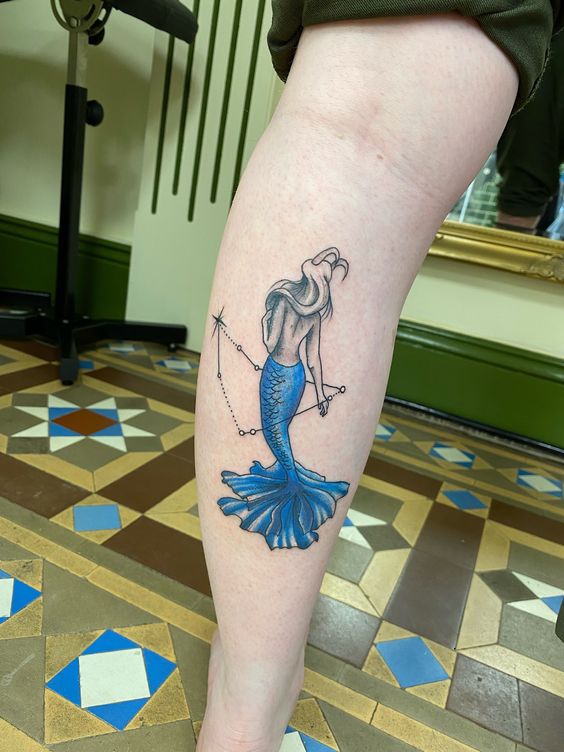 Tatouage Sirène Avec Cornes De Bouc Et Constellation Sur Le Mollet