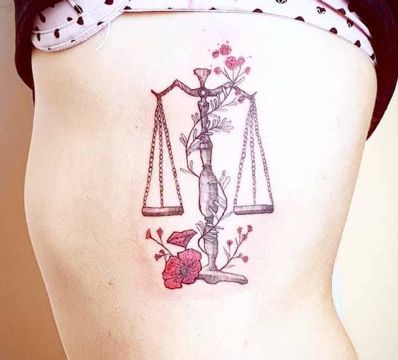Tatouage Balance Avec Fleurs Rouges Sur Les Côtes