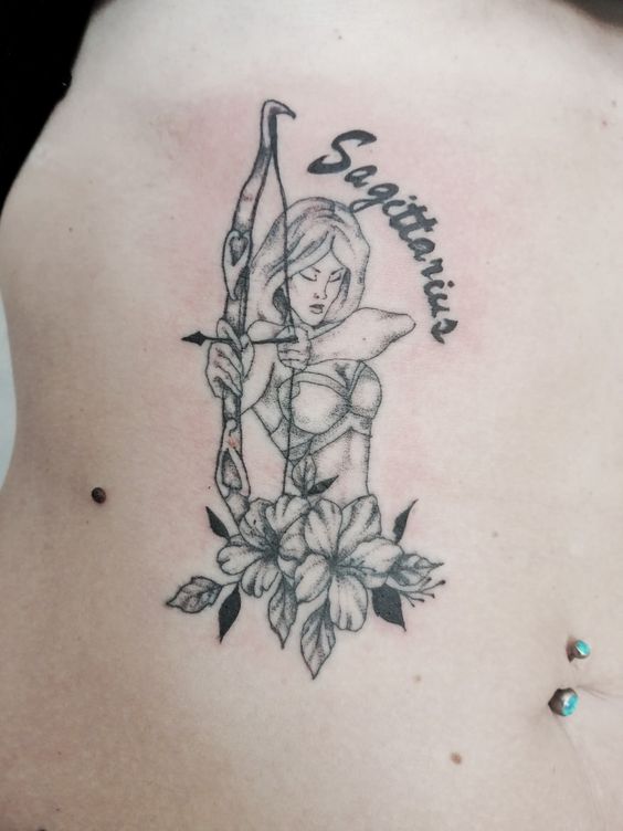 Tatouage Femme Archer Et Mot Sagittarius Sur Les Côtes