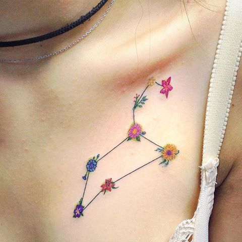 Tatouage Constellation Du Lion Avec Fleurs Colorées Sur La Clavicule