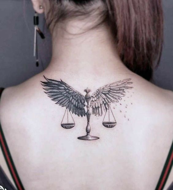 Tatouage Balance Avec Ailes En Noir Et Gris Sur Le Dos