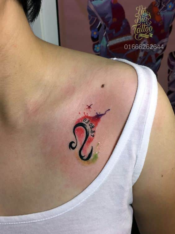 Tatouage Signe Lion Avec Aquarelle Et Date Sur La Clavicule