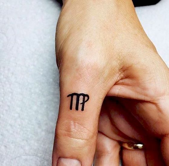 Tatouage Signe Vierge à L'encre Noire Sur Le Doigt