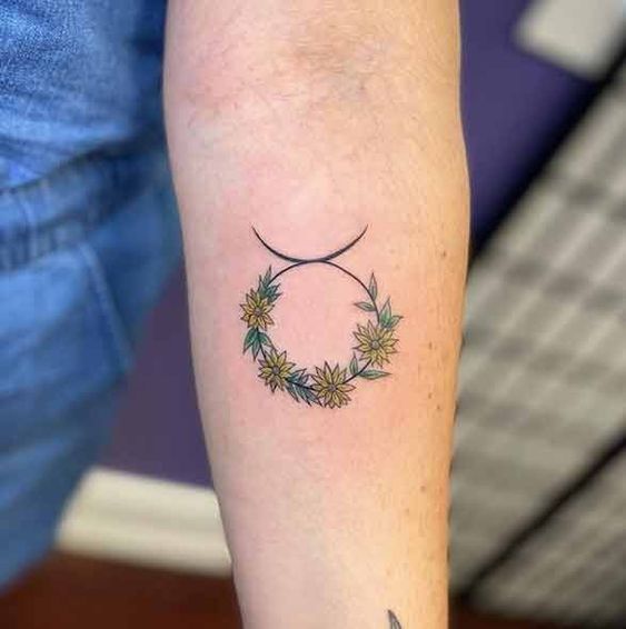 Tatouage Signe Taureau Avec Fleurs Jaunes Sur L'avant Bras