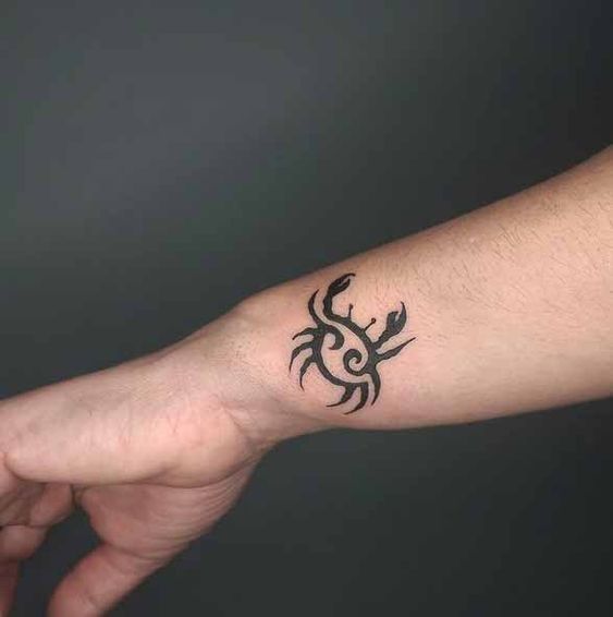 Tatouage Crabe Et Symbole à L'encre Noire Sur Le Poignet