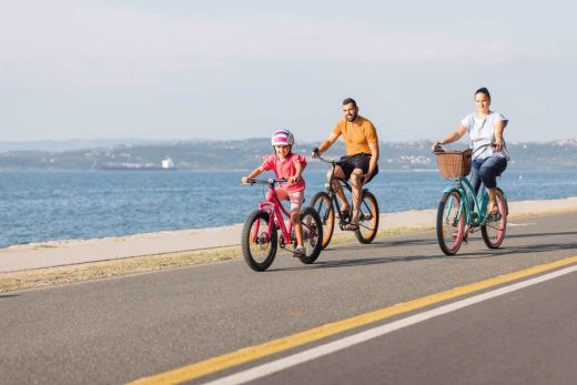 Mère, père et enfant à vélo près de la mer