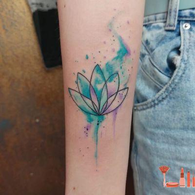 Tatouage Lotus Minimaliste Avec Aquarelles Verte Et Violette Sur L'avant Bras