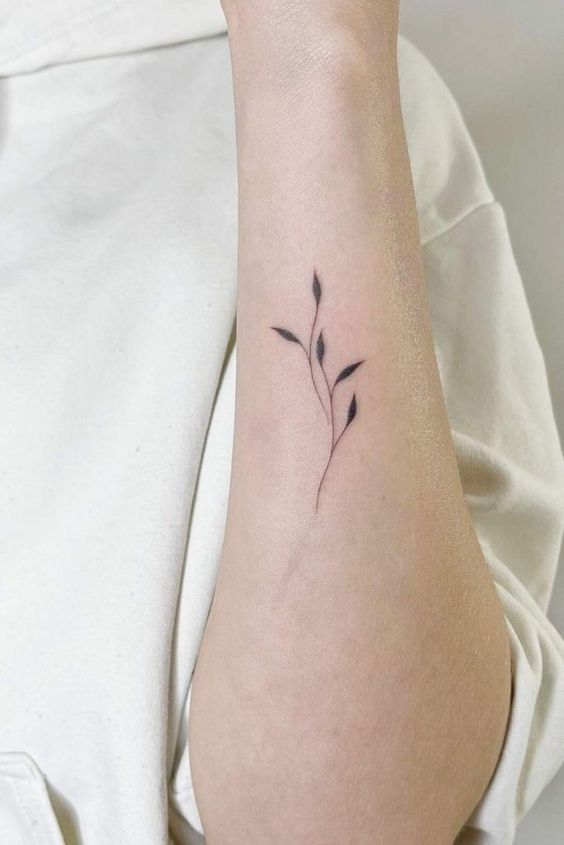 Tatouage Feuilles Noires Minimalistes Sur L'avant Bras