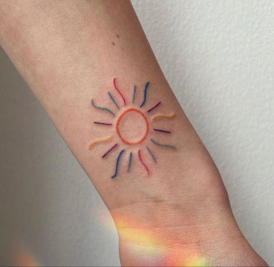 Tatouage Soleil Minimaliste Multicolore Sur Le Poignet