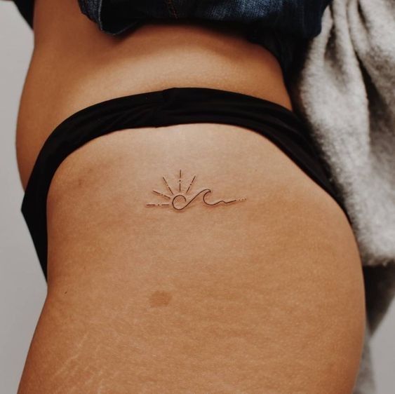 Tatouage Soleil Et Vague Minimaliste Sur La Hanche