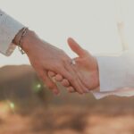 Couple Holding Hands With Engagement Rin